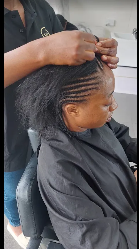 A stylist cornrowing a client's hair