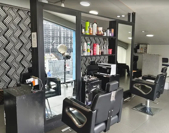Black salon chairs and mirrors in front of the black-and-white wave wallpaper