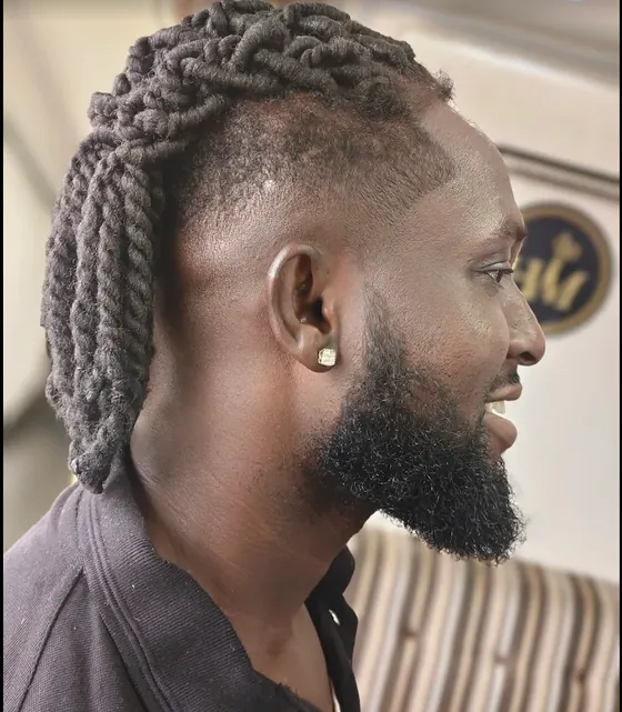 A client with twists, a fade and a trimmed beard, seen in profile